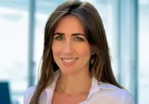 Portrait of Lois Ackerley in an office in front of a glass window